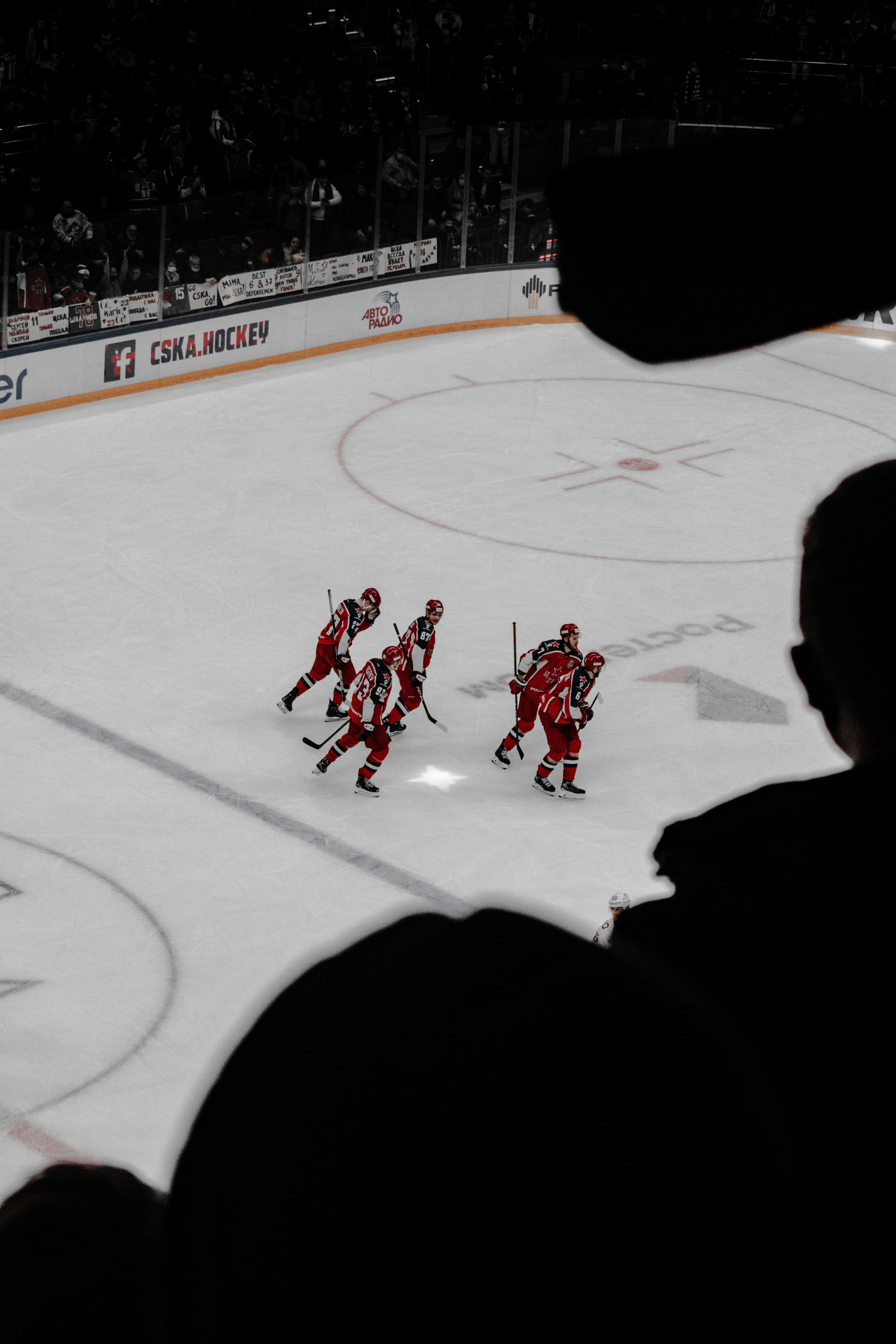 people playing ice hockey on ice field